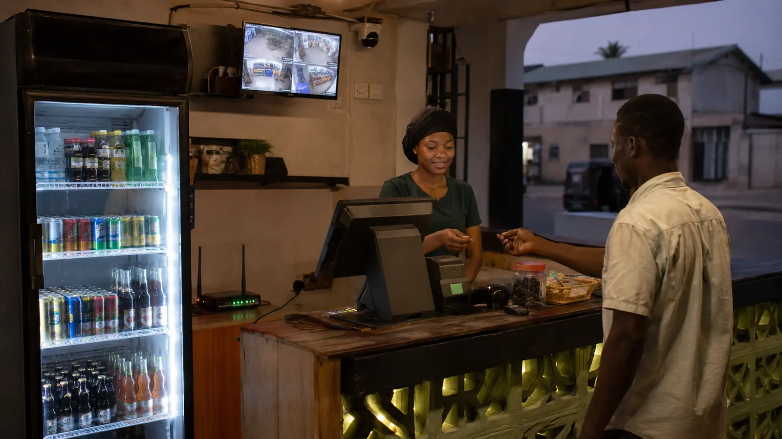 A Gambian shop serving a customer while refrigeration payment Wi-Fi and cameras remain powered