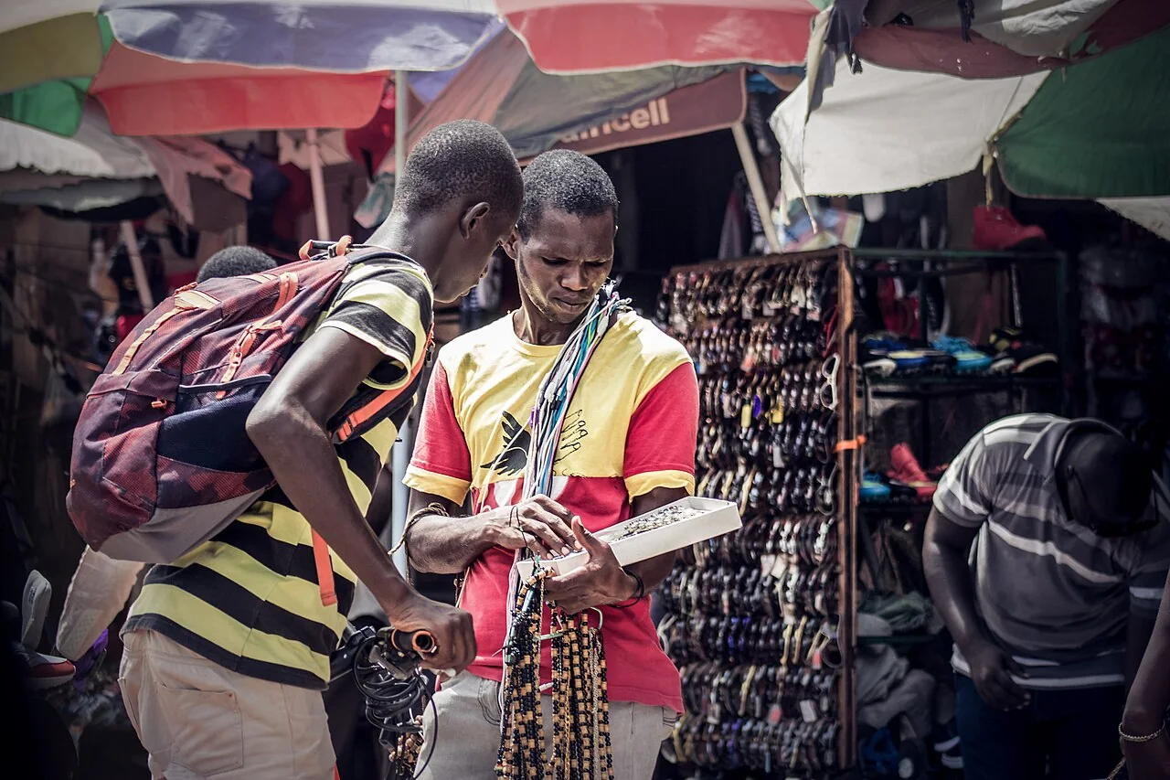 A seller and customer speaking across a stall in Serrekunda Market