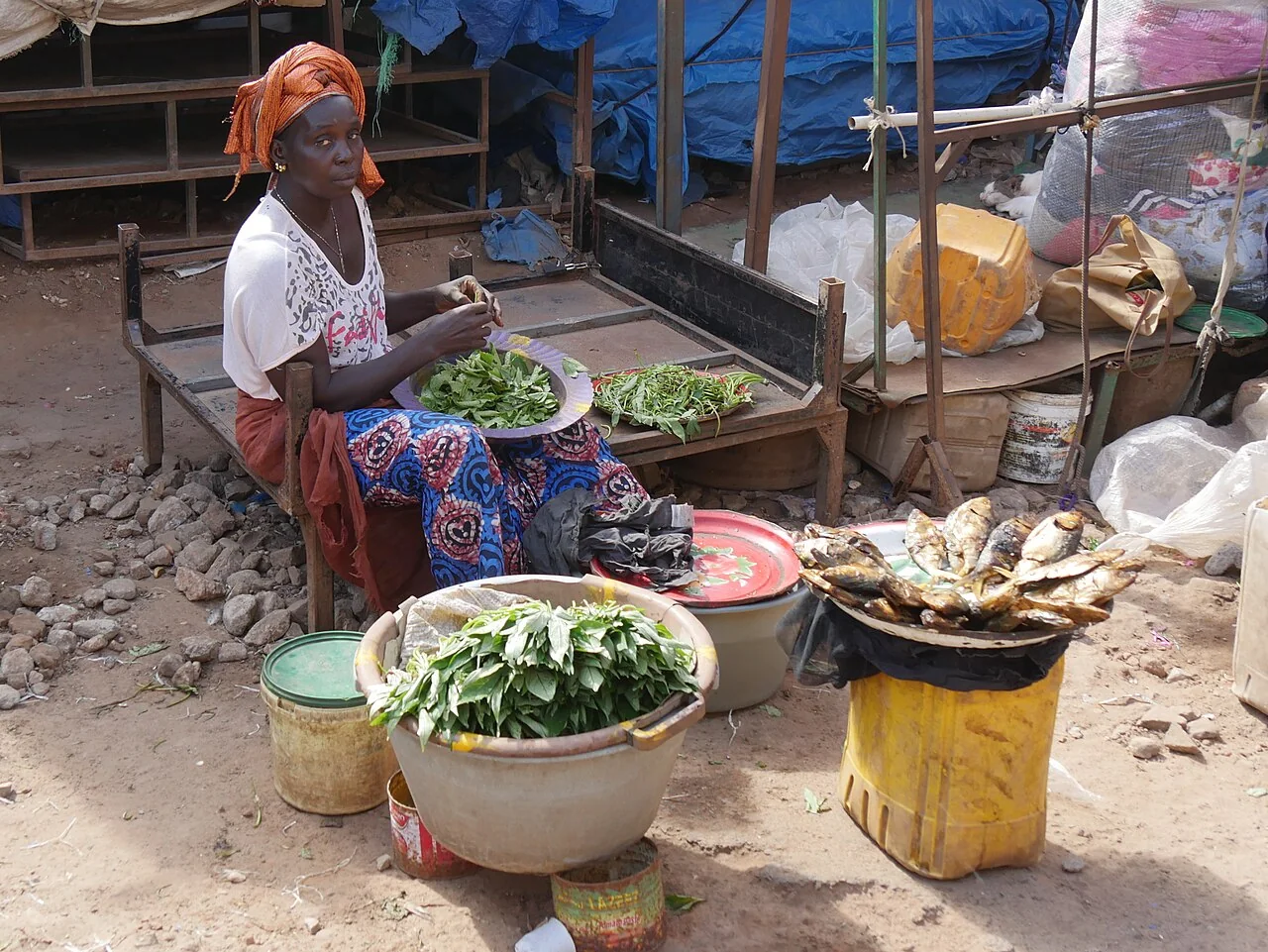 A woman selling leafy produce at a stall in Serekunda Market