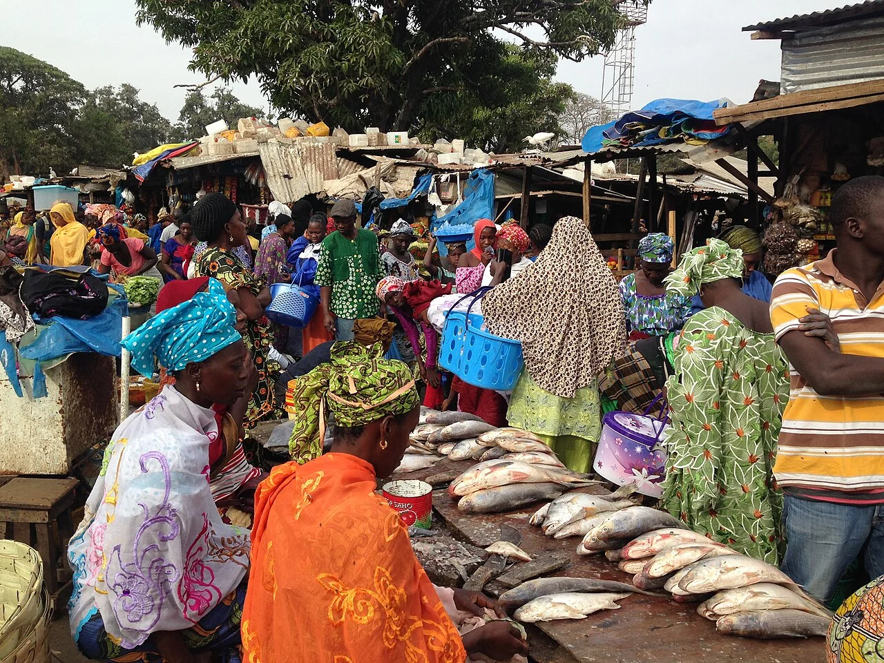 A vendor beside goods for sale in Serrekunda Market