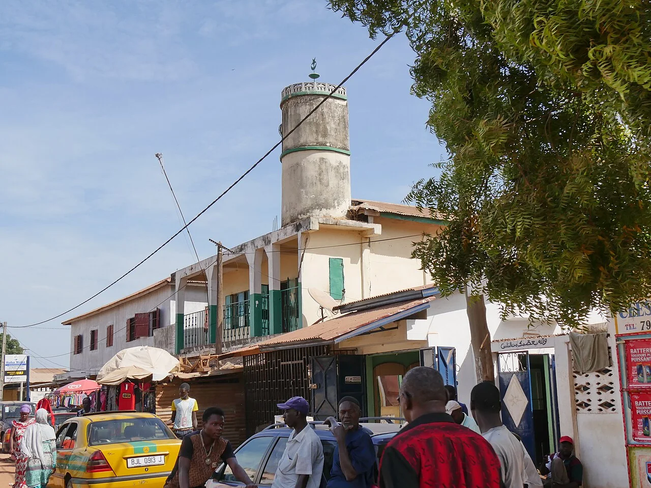 Traffic and yellow taxis moving through a street in Serekunda